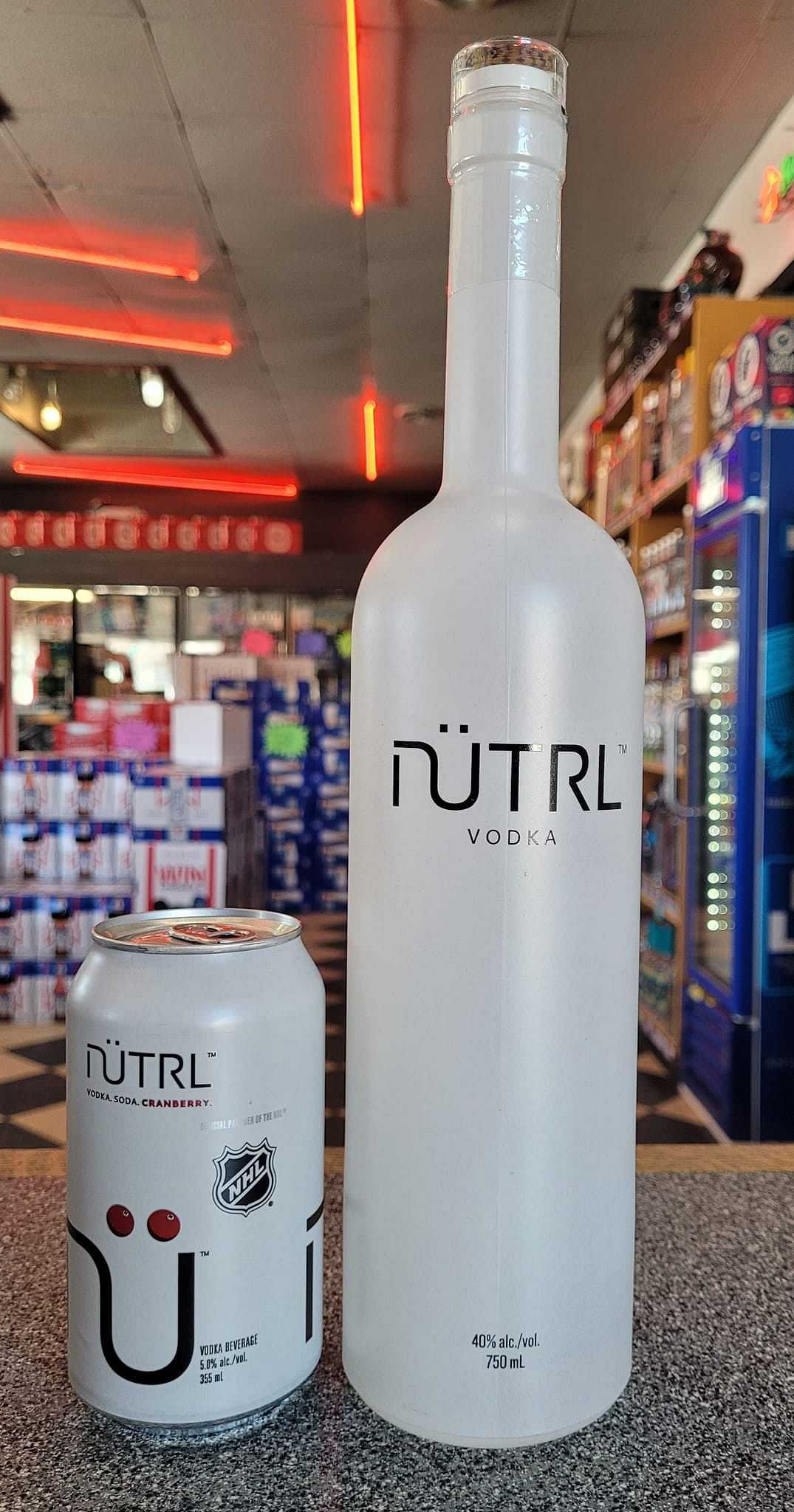 Nütrl Vodka can and bottle displayed on a store counter with shelves of beverages in the background.